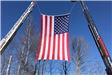 American flag displayed between two firetruck ladders