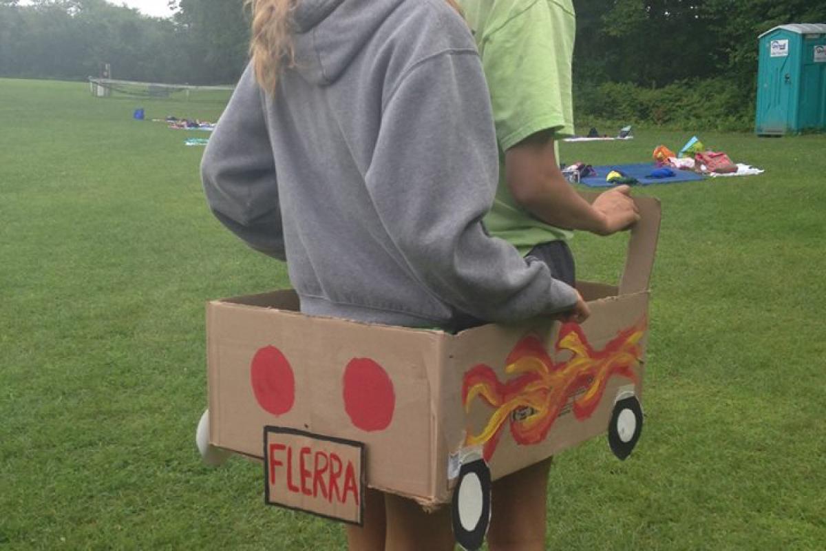 Two People Riding in a Cardboard Flerra Vehicle